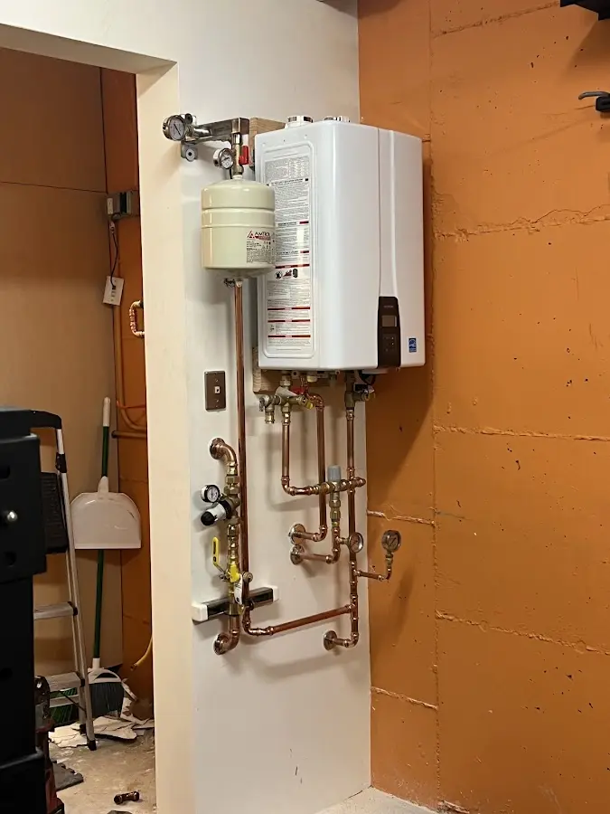 Plumbing technician inspecting water heater connections in Scituate